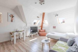 a white living room with a bed and a couch at La Suite des Épinoches - Parking Privé in Mâcon