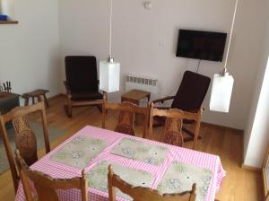 comedor con mesa, sillas y TV en Lake House en Kościan