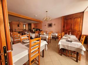 a restaurant with white tables and wooden chairs at Hôtel La Montagne Fleurie in Barèges +50 photos