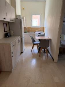 eine Küche mit einem Tisch und zwei Stühlen sowie einem Tisch und einer Theke in der Unterkunft Ipsos apartment in Ýpsos