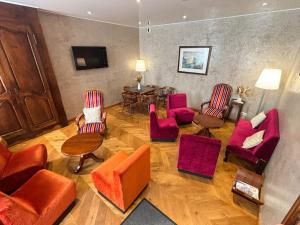 a living room with red chairs and a table at Hôtel La Montagne Fleurie in Barèges