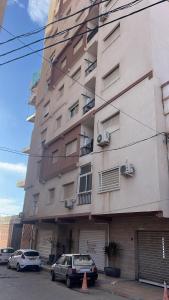 a large building with cars parked in front of it at Tarek in Oran