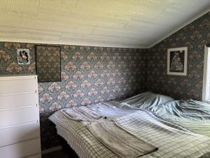 a bedroom with a bed with a floral wallpaper at Dockstavägen 7 in Docksta