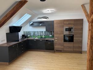 a large kitchen with black cabinets and a skylight at Casa del Mondo 3 in Sankt Aldegund