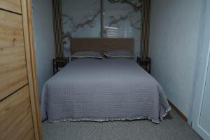 a bedroom with a bed with a white comforter at Vidikovac Cazin in Cazin