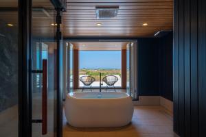 a bath tub in a bathroom with a window at THE SECOND Chousei Beach Village in Jōnouchi +43 photos