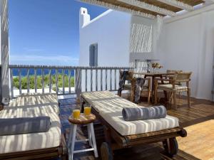 eine Terrasse mit Tisch und Stühlen auf einem Deck in der Unterkunft Nefeli Sunset Studios in Pollonia