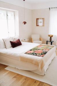 a bedroom with a large white bed with a rug on the floor at Porumbacu134 in Porumbacu de Sus