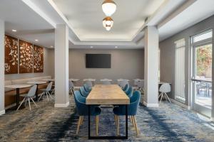 a conference room with a wooden table and blue chairs at TownePlace Suites by Marriott Phoenix Goodyear in Goodyear