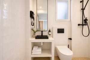 a bathroom with a toilet and a sink and a mirror at JIJI Suites Sénart in Combs-la-Ville +75 photos