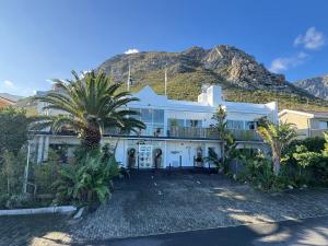 a large white house with a mountain in the background at 78on5th in Hermanus in Hermanus