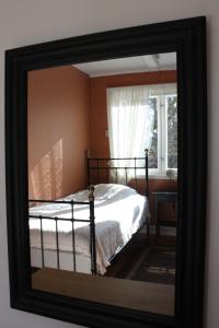 a mirror reflection of a bed in a bedroom at Hen stasjon Venteværelset in Hen +6 photos