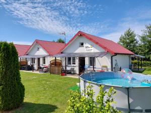 a house with a swimming pool in the yard at Domki letniskowe Reda in Rusinowo