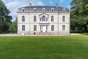 a large white house with a large grass field at Domaine du Béron - Chateau et gites in Cappelle-en-Pévèle