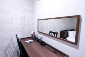a mirror on a wall above a wooden table at ホテル ニューウェーブ in Okayama +3 photos