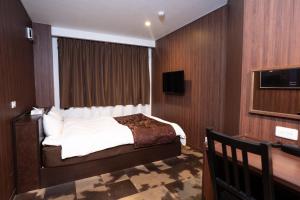 a hotel room with a bed and a television at ホテル ニューウェーブ in Okayama