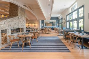 a restaurant with tables and chairs and a fireplace at Renaissance Paris Hippodrome de St. Cloud Hotel in Rueil-Malmaison
