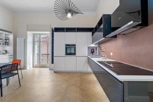 a kitchen with white cabinets and a dining room at Borgogna Living in Vercelli