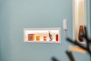 a mirror on a wall with a vase on a shelf at Borgogna Living in Vercelli +20 photos