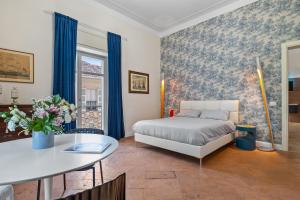 a bedroom with a bed and a table at Borgogna Living in Vercelli