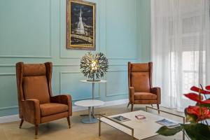a living room with two chairs and a table at Borgogna Living in Vercelli