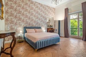 a bedroom with a bed with a blue headboard at Borgogna Living in Vercelli