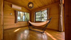 a hammock in the corner of a room with windows at Balistyle Tateyama View in Tateyama
