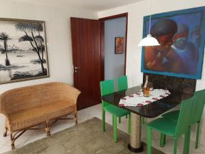 comedor con mesa negra y sillas verdes en Casa Mar e Lua, en Natal