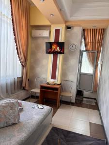 a living room with a couch and a tv on the wall at Отель "VOSTOK" in Yalanghoch
