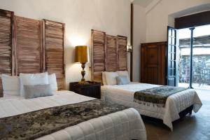 ein Hotelzimmer mit zwei Betten und einem Fenster in der Unterkunft Hotel Villa 1927 in Chapala