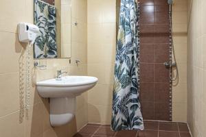 a bathroom with a sink and a shower at Lotos Hotel in Balchik