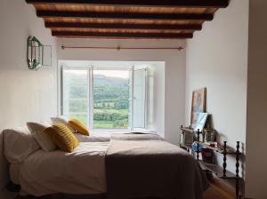 a bedroom with a bed and a large window at Casa Malde in Cedeira