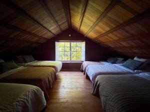 a room with four beds in a room with a window at Casa Malde in Cedeira