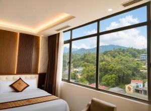 a room with a bed and a large window at Tv Hotel in Cao Bằng