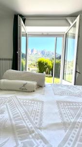 a bedroom with a white bed with a large window at Villa Amore in Oltre il Colle
