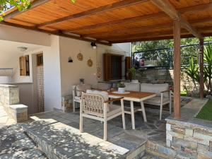a patio with a table and chairs under a wooden pergola at Aegean View Mikro Pelion in Mikro