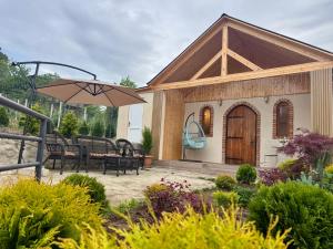 a small house with a patio and an umbrella at House of Warmth in Bagdatʼi