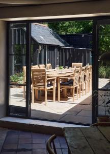 a wooden table and chairs on a patio at Historic Brewery Cottage in Dorset Village Sleeps 10 in Fontmell Magna