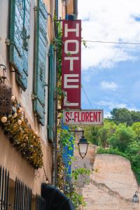 a sign on the side of a building with a sign for a store at Hôtel Saint-Florent, à 2 pas du Théatre Antique d'Orange in Orange