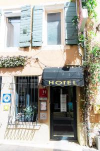a building with a hotel sign on the front of it at Hôtel Saint-Florent, à 2 pas du Théatre Antique d'Orange in Orange