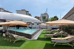 ein Pool mit Stühlen und Sonnenschirmen auf einem Gebäude in der Unterkunft Borgo Double V in Neapel