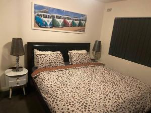 a bedroom with a bed and a painting on the wall at Scarborough Beach Shack in Perth +28 photos