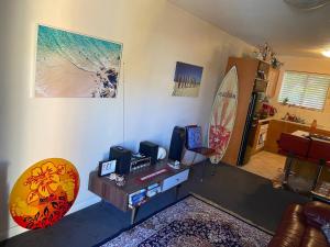 a living room with a table and a surfboard at Scarborough Beach Shack in Perth