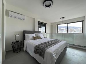 a bedroom with a large bed and a large window at Athenean Gem Near Metro Mall in Athens