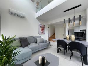 a living room with a couch and a table and chairs at Athenean Gem Near Metro Mall in Athens