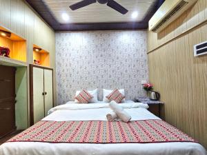 a bedroom with two beds and a ceiling fan at Zipcode Kashi in Varanasi +19 photos