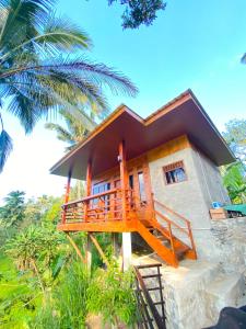 a house with a staircase leading up to it at Forest Side Bungalow in Tetebatu