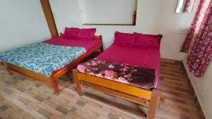 two beds sitting next to each other in a room at Emerald home stay in Kodaikānāl +26 photos