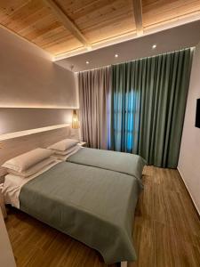 a bedroom with a large bed with a window at Patras Rooms est 1990 in Fournoi