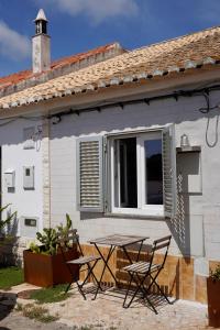 a table and chairs in front of a house at Toca da raposa in Raposeira